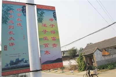 10月15日，陵城镇星家村临街电线杆上悬挂的提倡“孝”的标语。新京报记者 周清树 摄